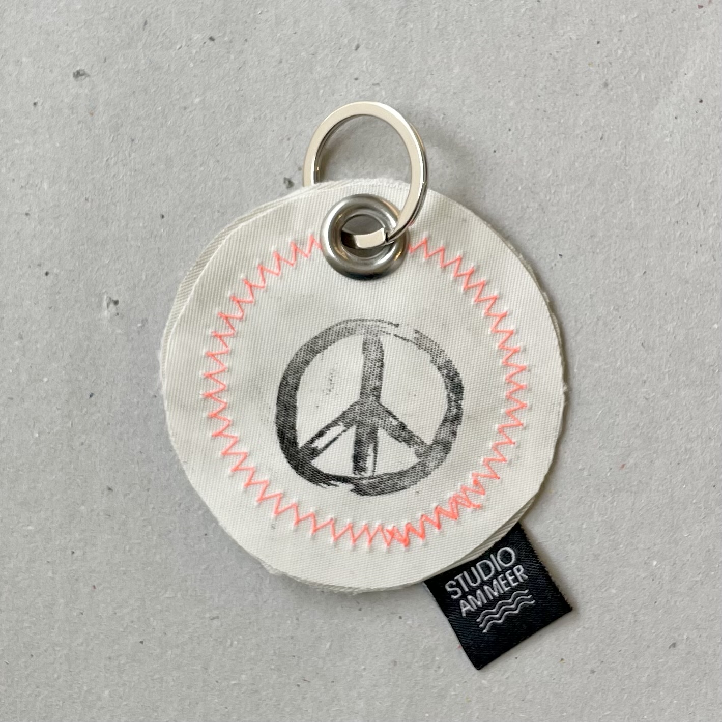 Segeltuch Schlüsselanhänger "Peace-Zeichen" D7cm, weiß/neonorange/schwarz