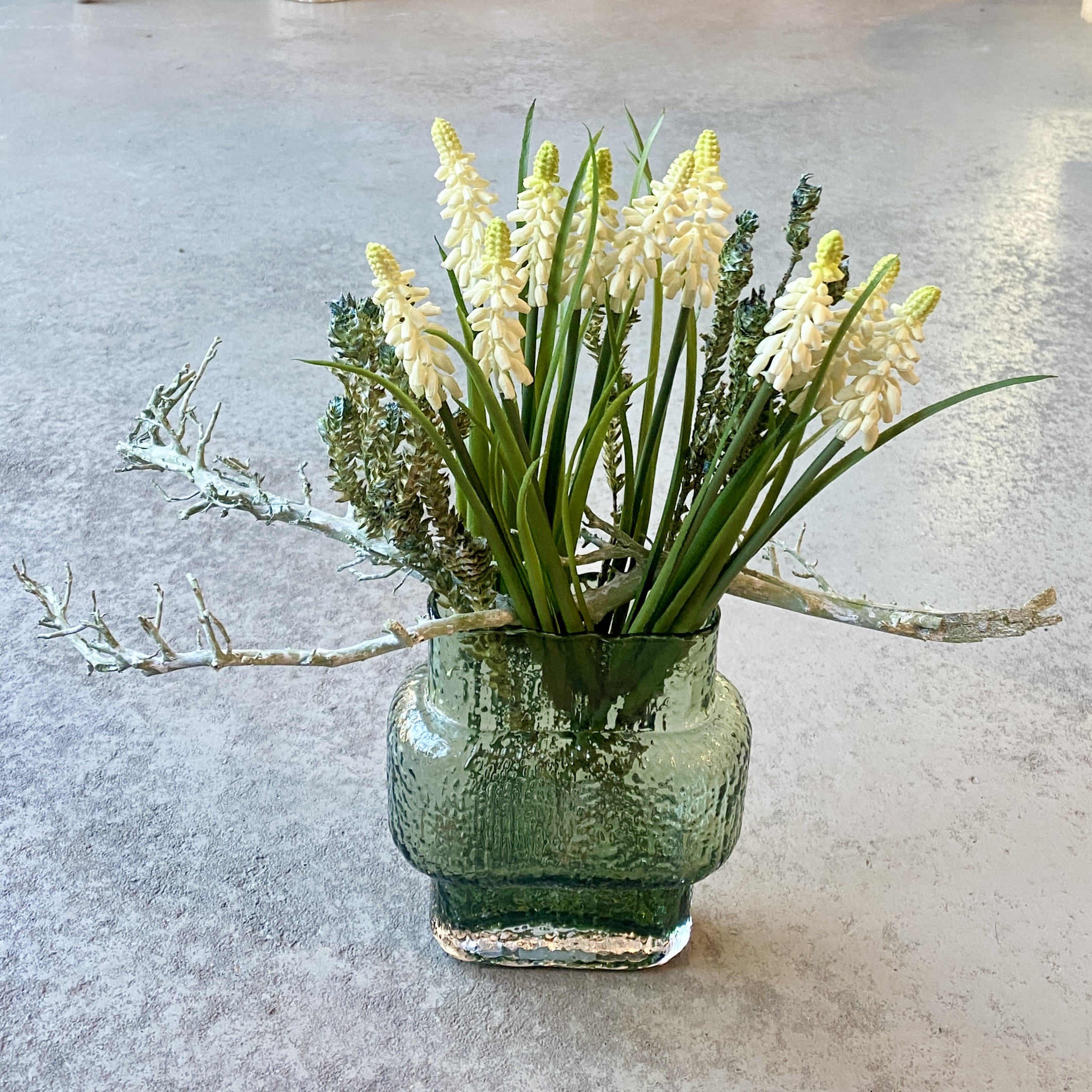 Glasvase mit Perlhyazinthen und Zweigen H34cm, grün