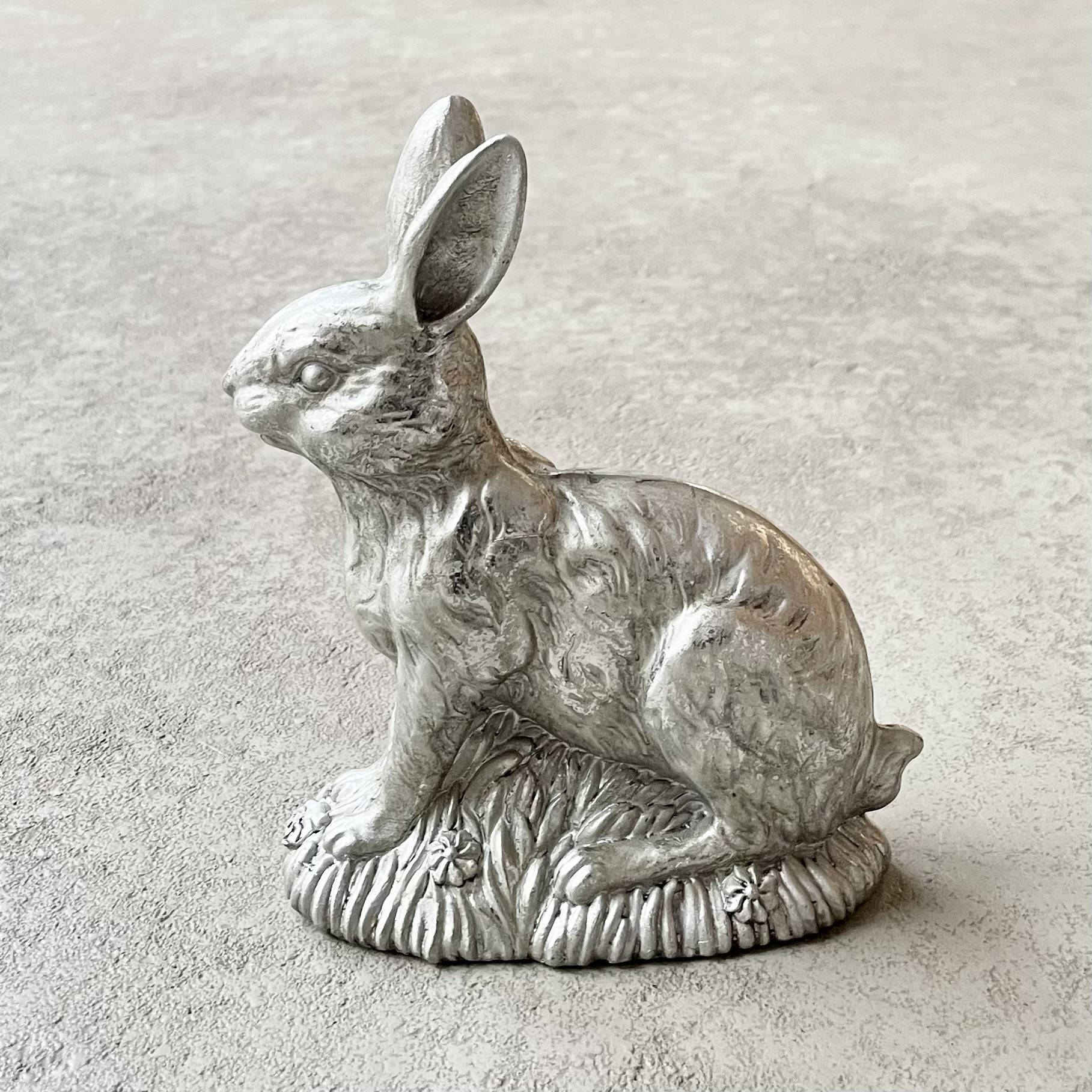 Poly-Hase sitzend auf der Blumenwiese H18cm, antiksilber