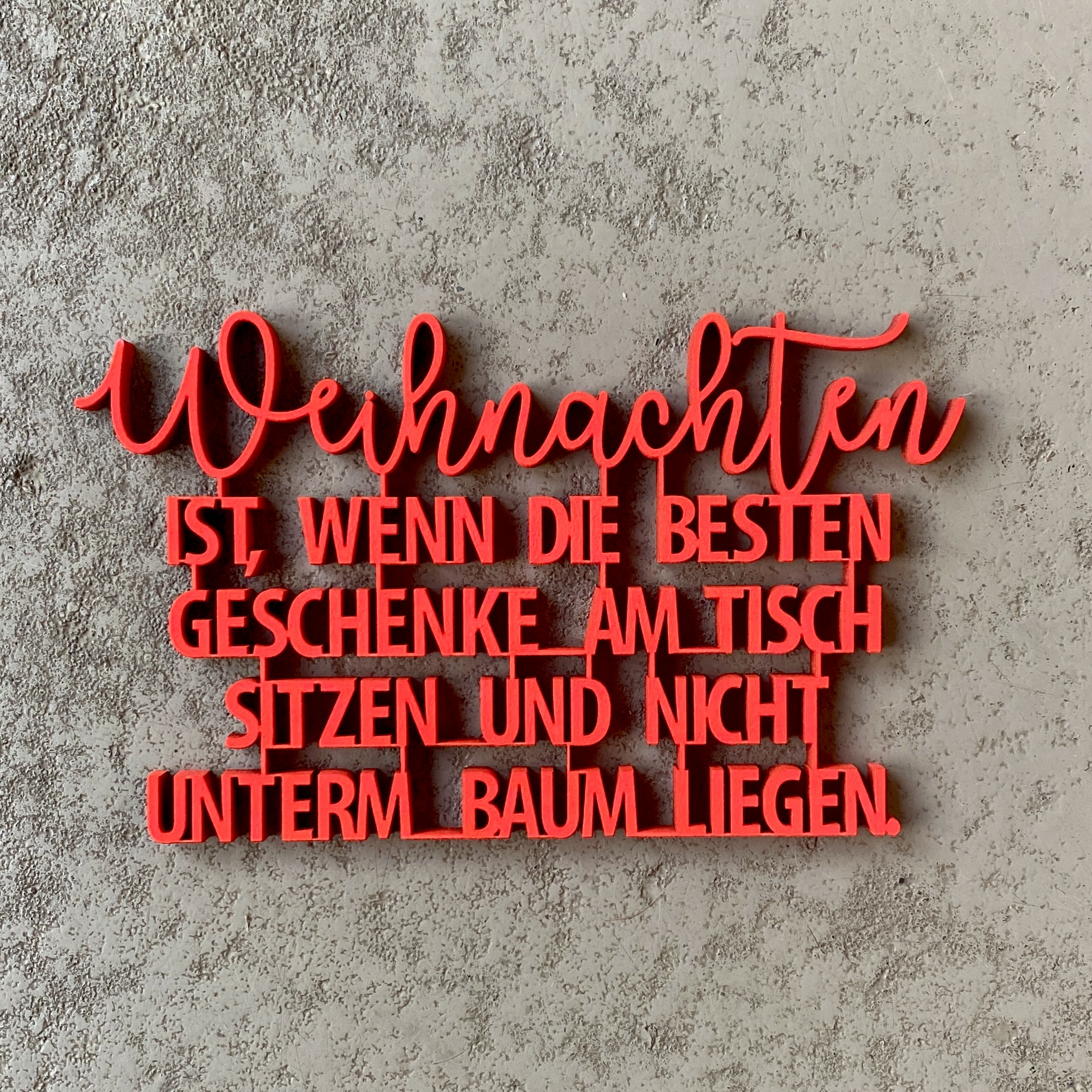 Schriftzug "Weihnachten IST, WENN DIE BESTEN GESCHENKE AM TISCH SITZEN UND NICHT UNTERM BAUM LIEGEN" neonrot