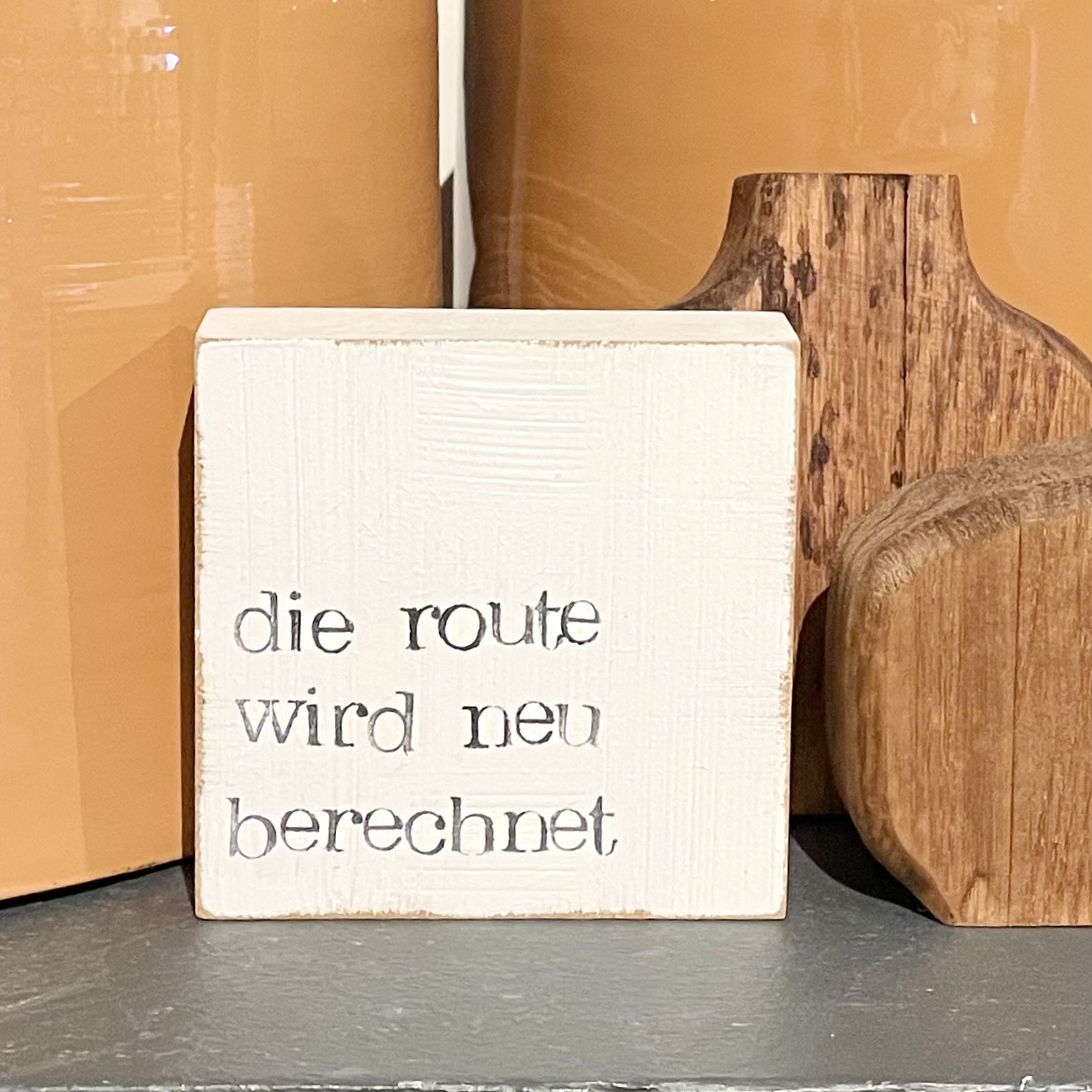Textplatte "die route wird neu berechnet" 10x10cm, weiß/schwarz