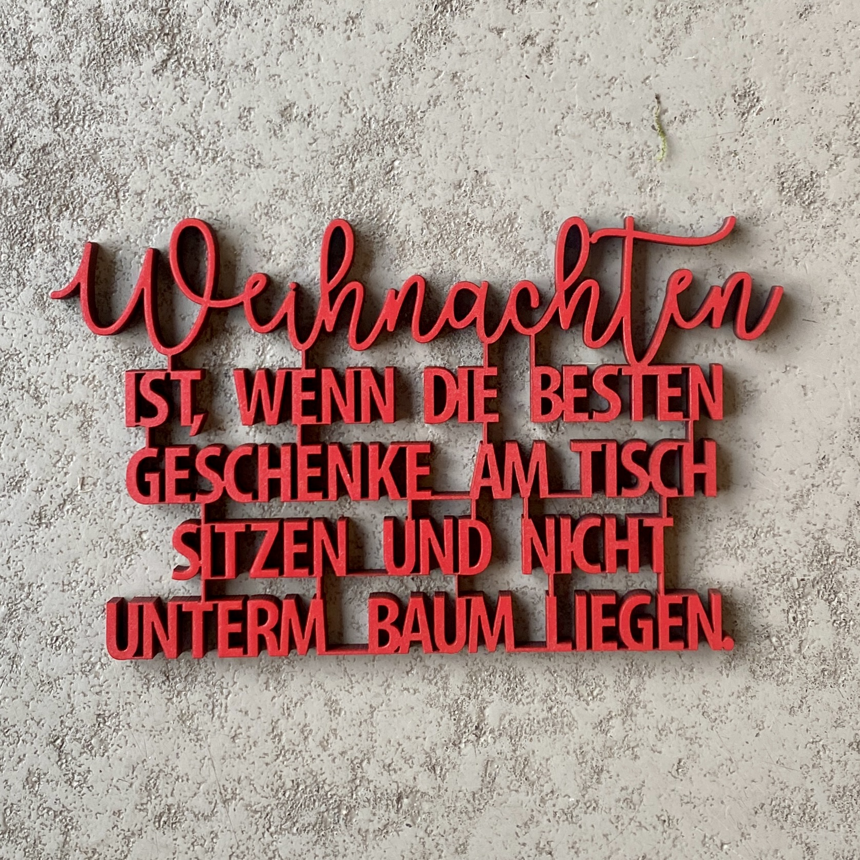 Schriftzug "Weihnachten IST, WENN DIE BESTEN GESCHENKE AM TISCH SITZEN UND NICHT UNTERM BAUM LIEGEN" rot